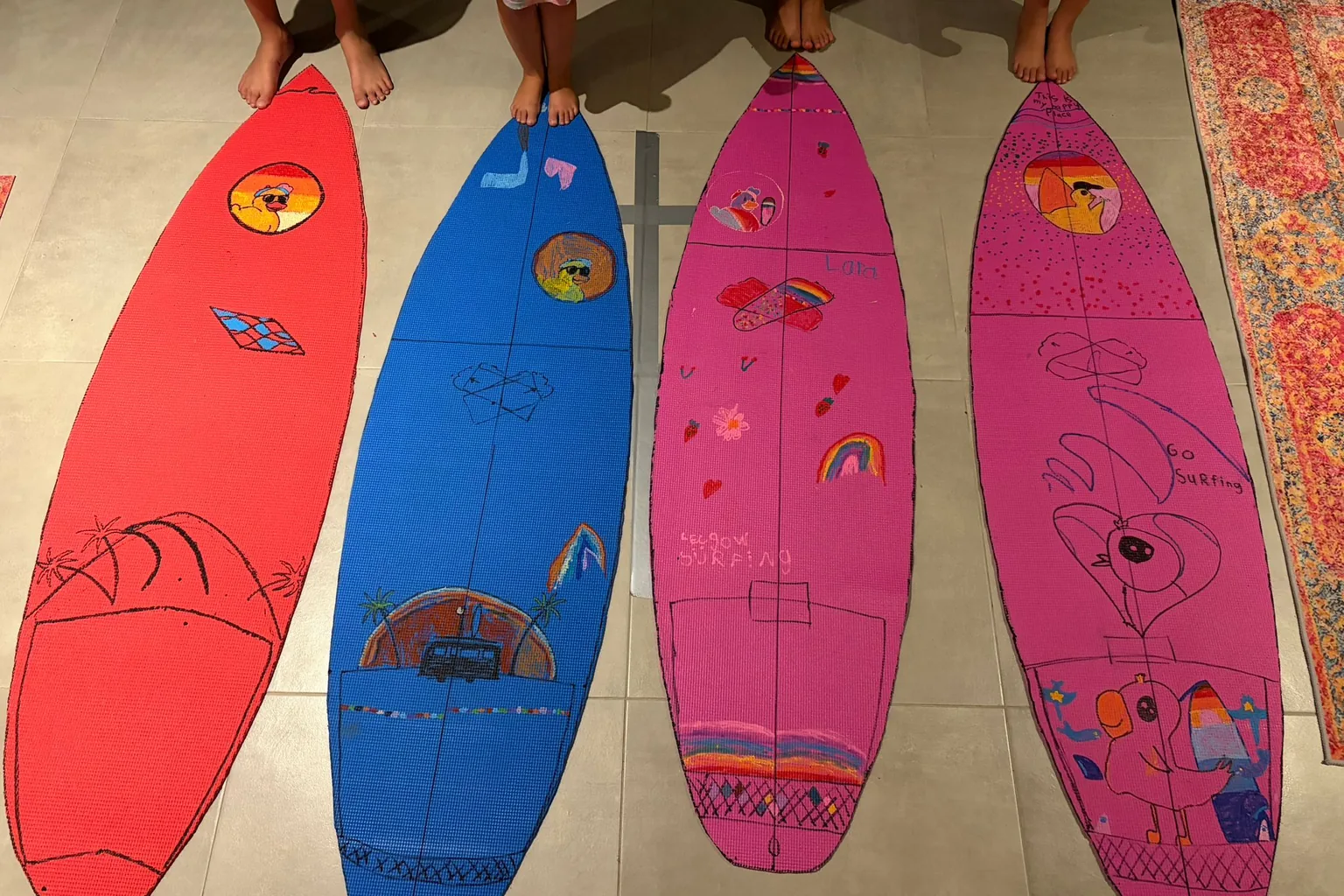 Four soft-top surfboards painted by the Duckies, seen from above.