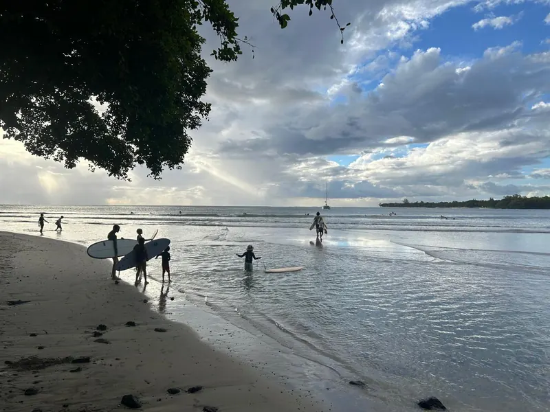 Duckies carrying their boards into the water at dusk.
